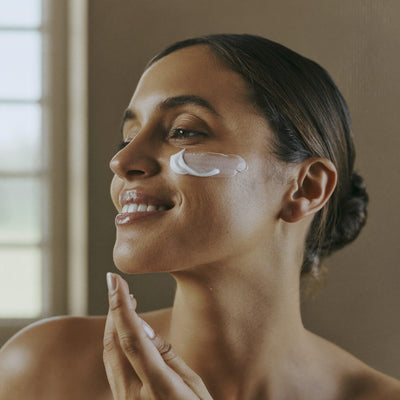 Woman smoothing natural beef tallow face cream onto her cheek — Moose's Tallow beef tallow face cream and facial care