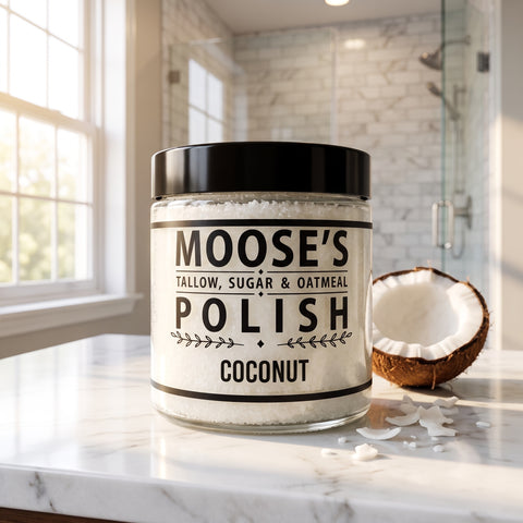 Coconut Sugar Scrub jar on a white marble bathroom counter with a fresh coconut