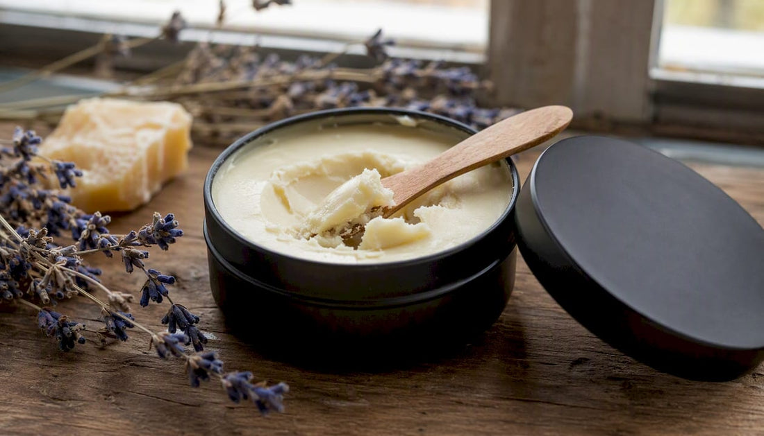 Open beeswax balm in black tin with wooden spatula