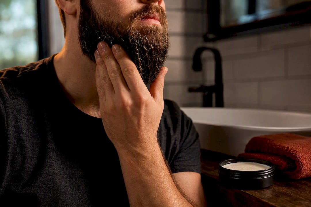 Hand smoothing balm through a damp beard