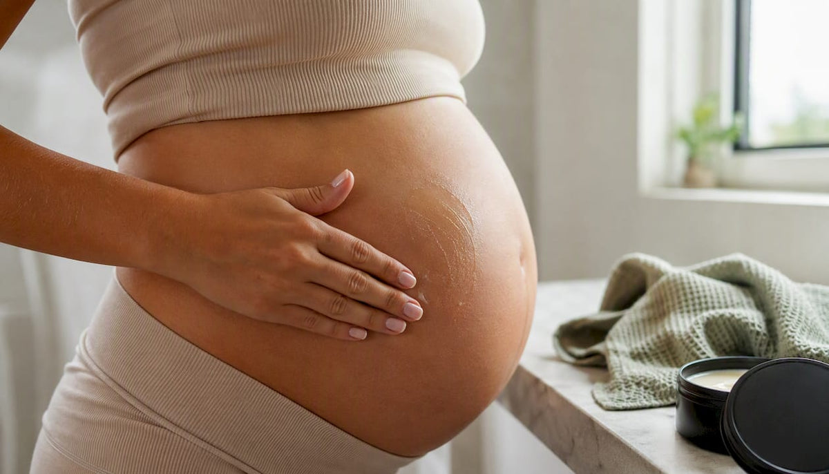Pregnant woman applying balm to her belly