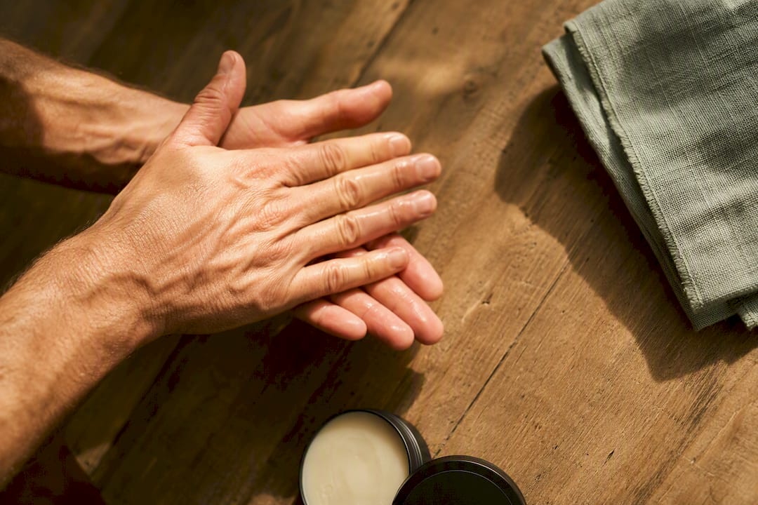 Hands warming a small dab of tallow butter