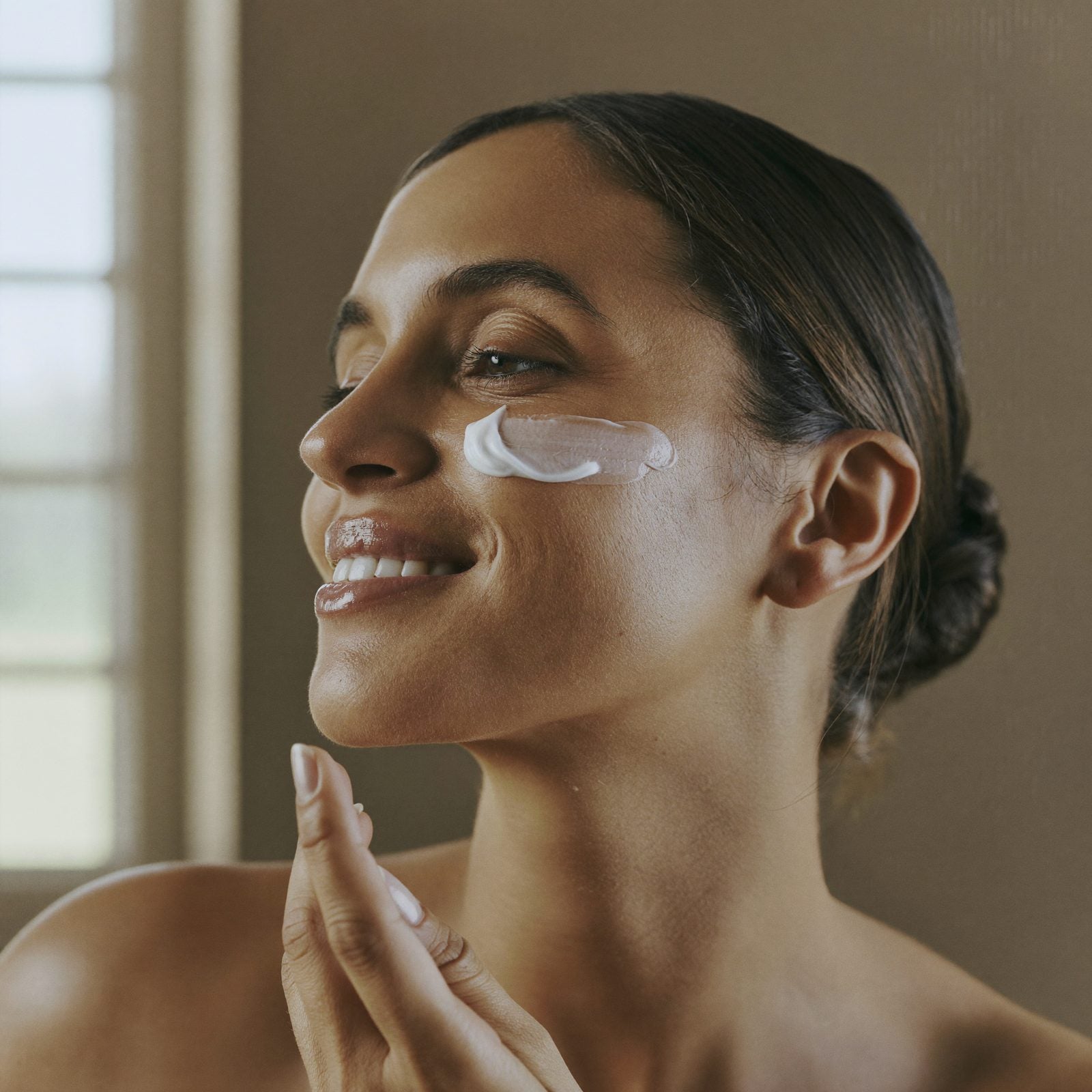 Woman smoothing natural beef tallow face cream onto her cheek — Moose's Tallow beef tallow face cream and facial care