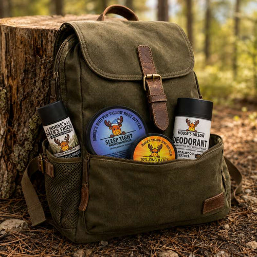 Olive canvas hiking backpack in the woods with Moose's Tallow Hiker's Friend bug balm, Sleep Tight body butter, Sun Balm 10% zinc, and Deodorant tucked in the pockets