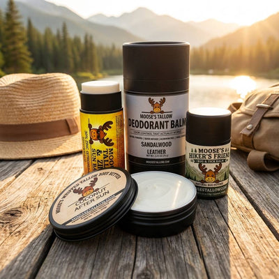 Natural Summer Skincare Essentials — Moose's Tallow zinc sun balm, deodorant, Hiker's Friend bug and tick balm, and coconut after sun butter by a summer lake