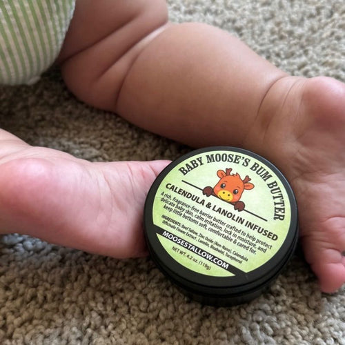 Baby Bum Butter tin held in baby's feet