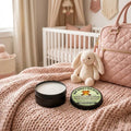 Baby Bum Butter natural tallow and zinc oxide diaper cream — open and closed tins with the Baby Moose's Bum Butter calendula and lanolin label on a blush-pink knit blanket in a baby girl's nursery