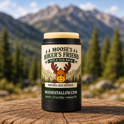 Moose's Hiker's Friend natural bug and tick balm stick on a stump with mountains behind